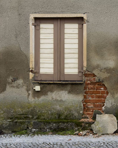 Eine Hauswand ist von feuchtem Mauerwerk betroffen.